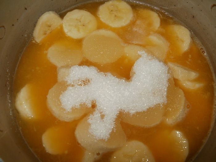 В кастрюле смешиваем бананы, сок и сахар